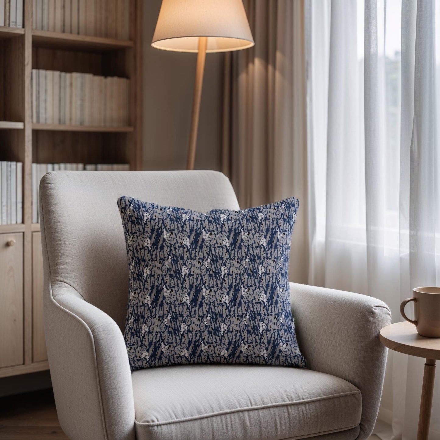 Beige armchair with a blue patterned pillow in a cozy living room setting.