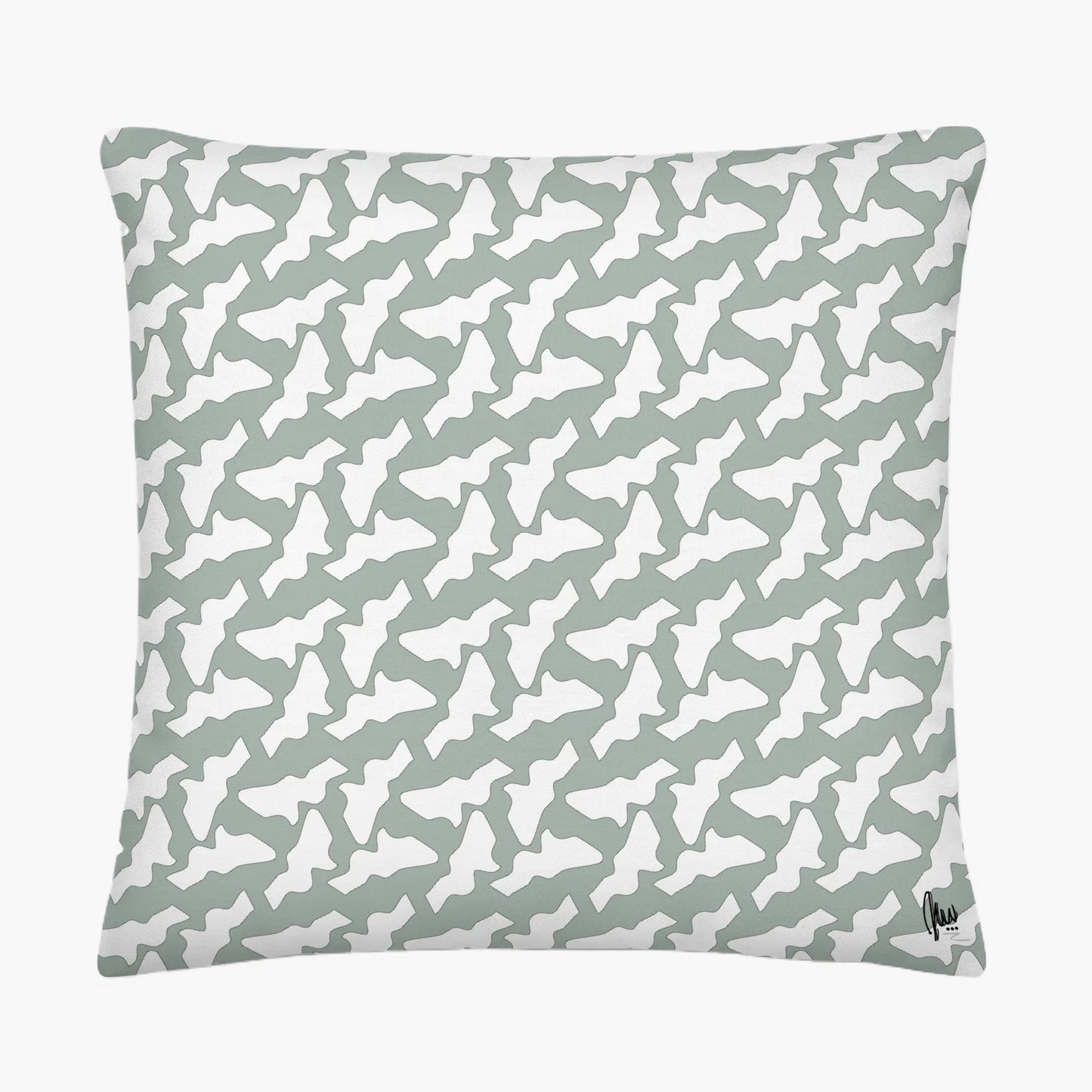 Patterned pillow with white shapes on a light gray background