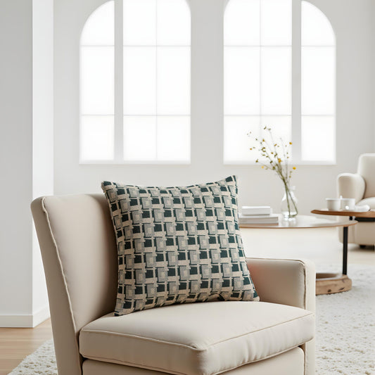 Beige armchair with a patterned pillow in a bright room with large windows.