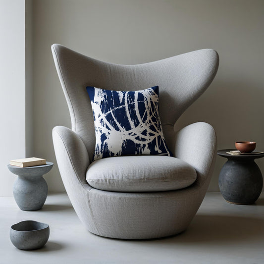 Gray egg-shaped chair with a blue and white patterned pillow, surrounded by small tables and bowls.