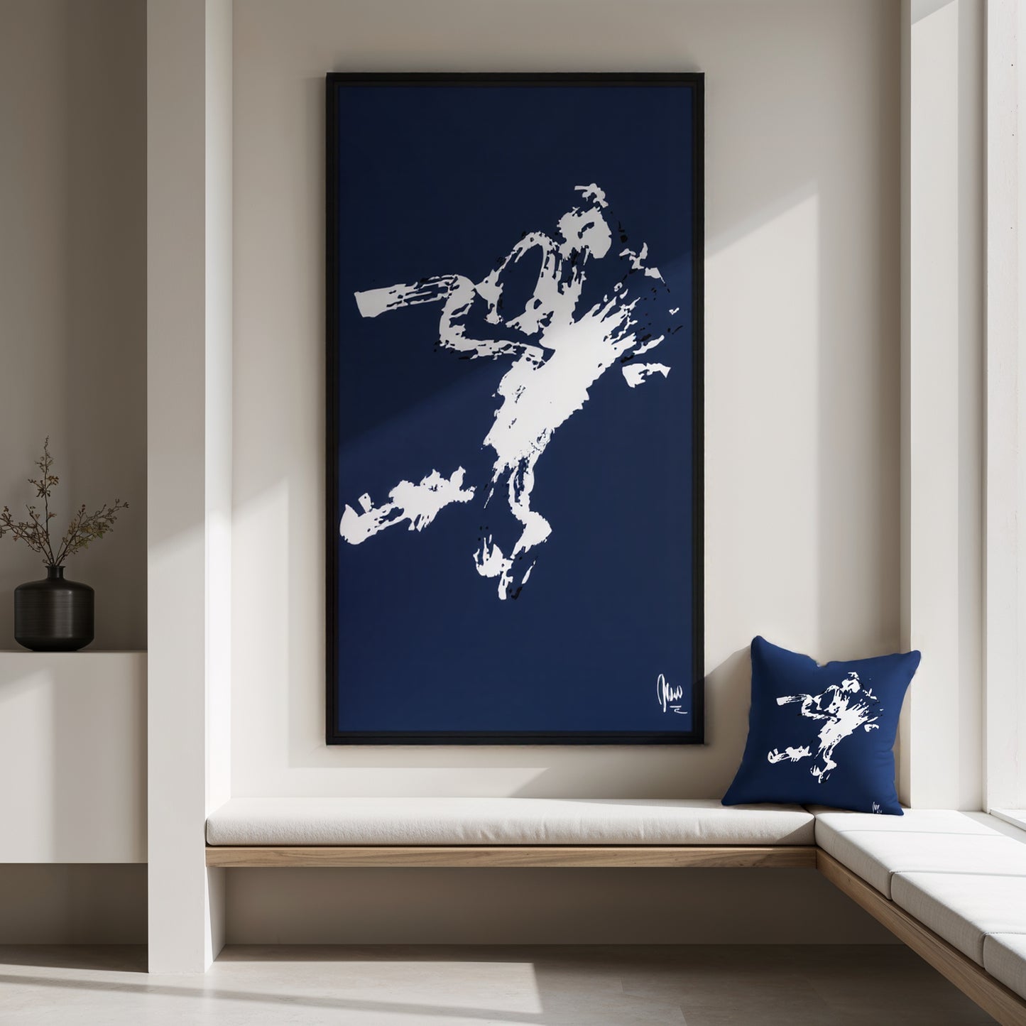 Framed artwork of a white silhouette on a blue background, placed above a window seat with a matching pillow.