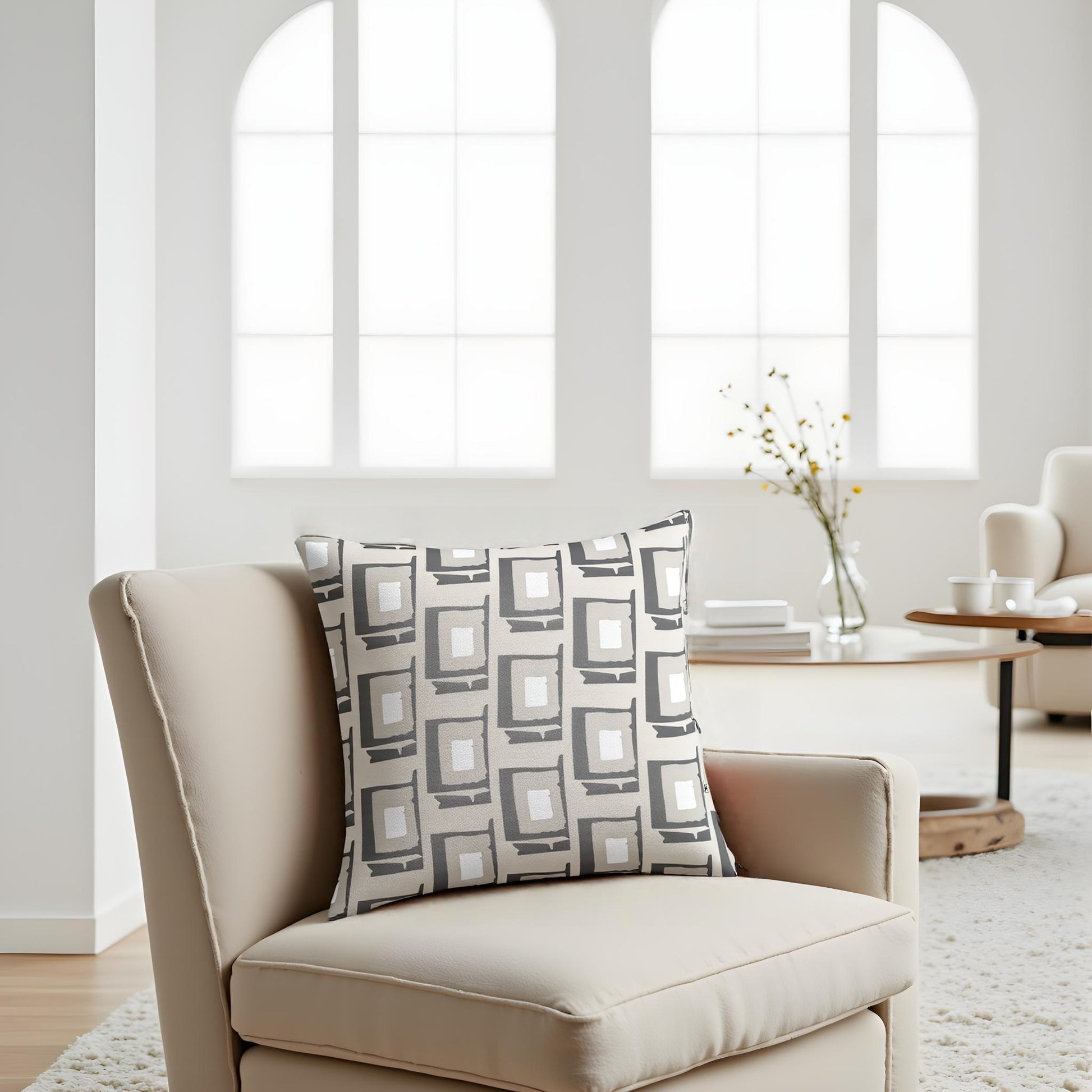 Beige armchair with a patterned pillow in a bright living room.